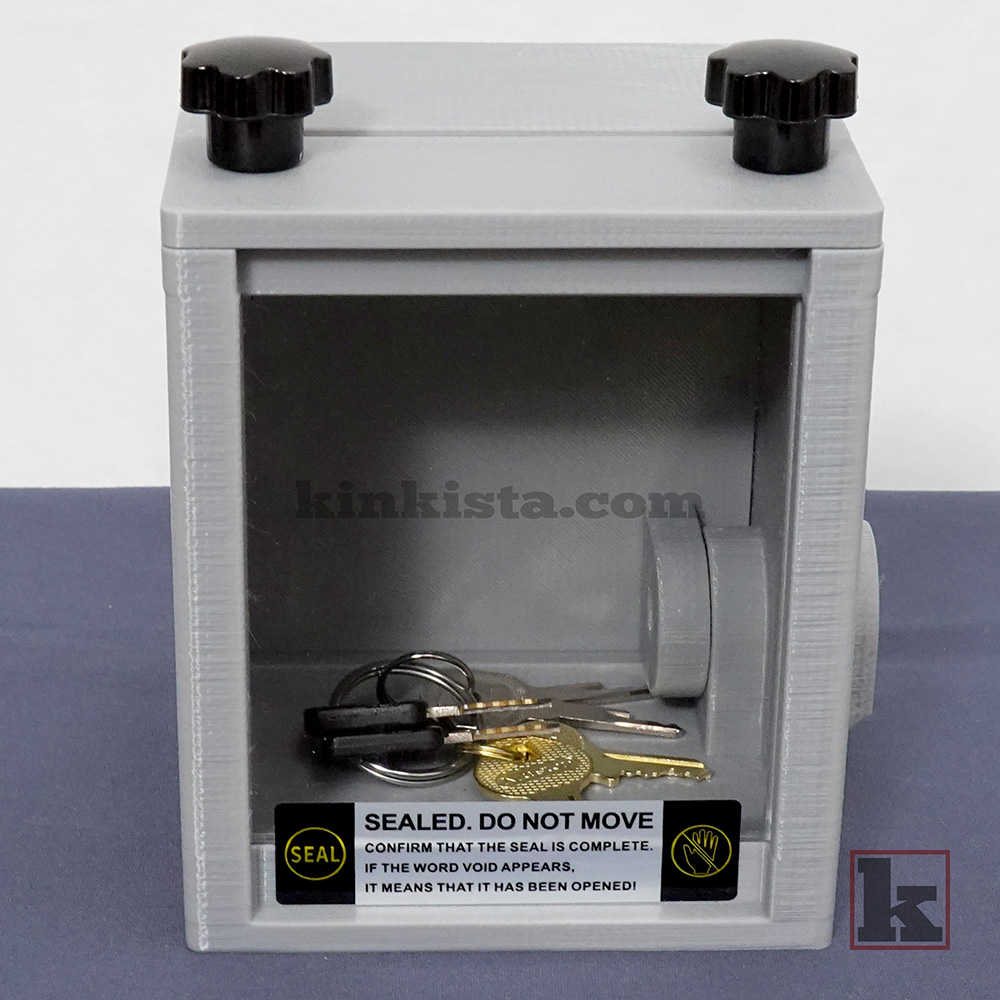 Emergency keybox designed for extended bondage and power exchange play, showing keys visible through window